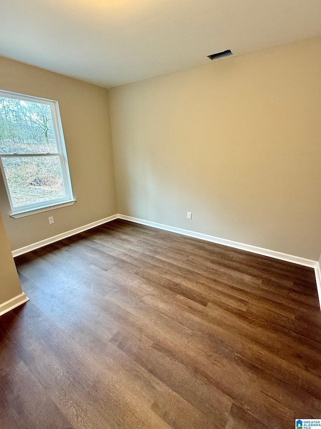 unfurnished room with dark hardwood / wood-style flooring