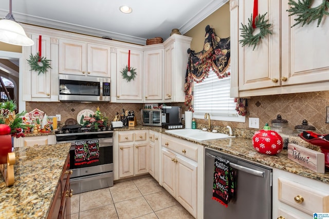 kitchen featuring sink, decorative backsplash, light tile patterned floors, light stone countertops, and appliances with stainless steel finishes