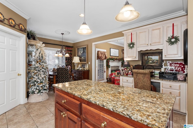 kitchen featuring a center island, light tile patterned floors, decorative light fixtures, and ornamental molding