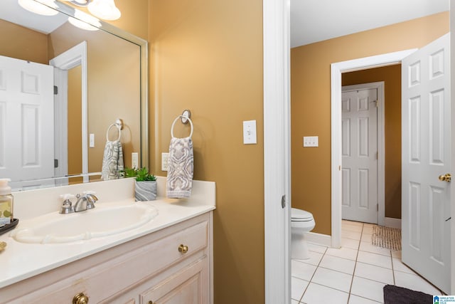 bathroom with tile patterned flooring, vanity, and toilet