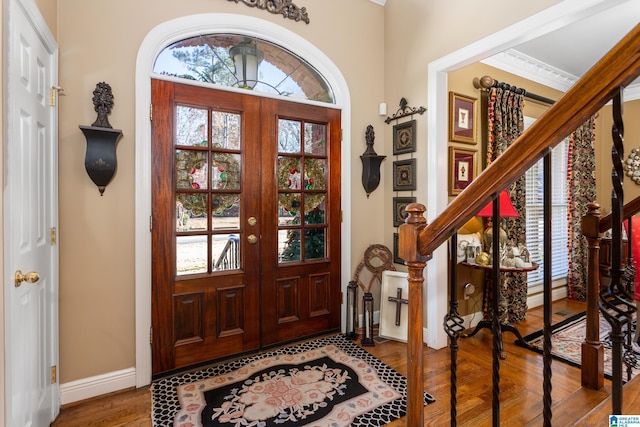 entrance foyer with crown molding, french doors, and hardwood / wood-style floors