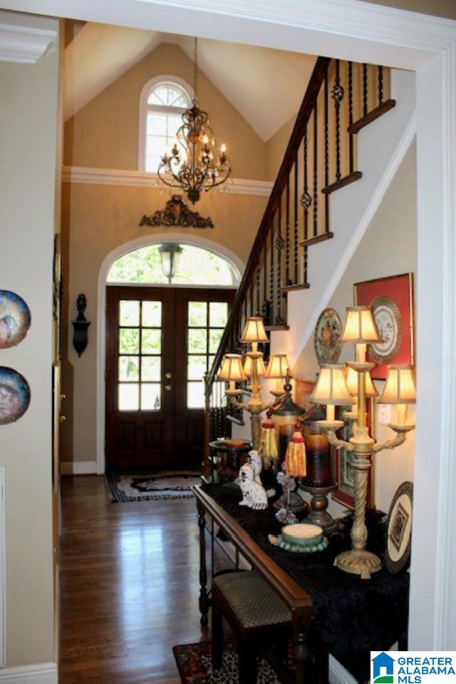 foyer entrance with a chandelier, french doors, dark hardwood / wood-style floors, and lofted ceiling