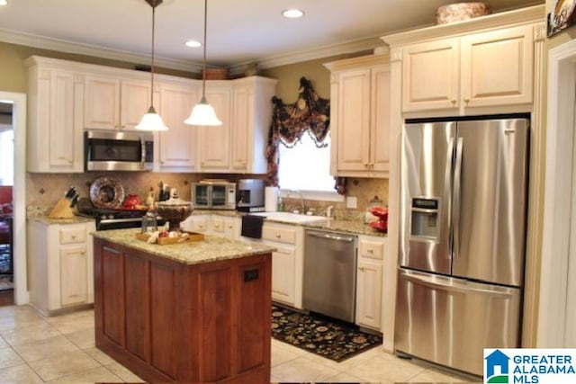 kitchen featuring pendant lighting, a center island, light stone countertops, appliances with stainless steel finishes, and tasteful backsplash