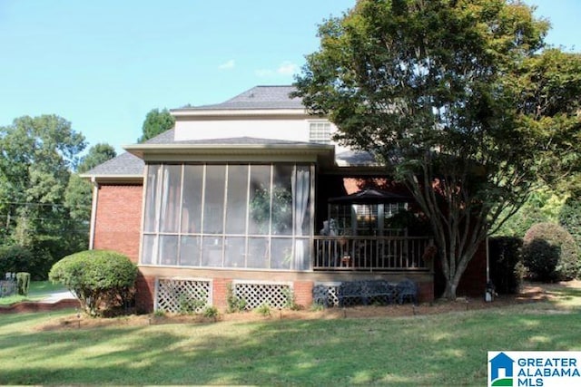 view of property exterior featuring a sunroom and a yard