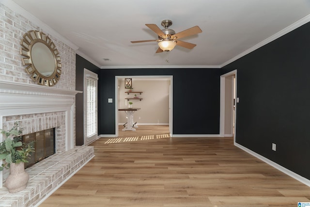 living room with light hardwood / wood-style floors, a brick fireplace, ceiling fan, and ornamental molding