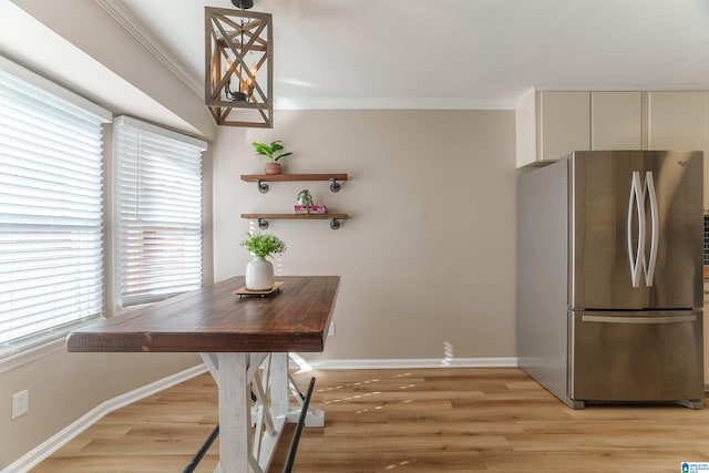 dining room with crown molding and light hardwood / wood-style flooring