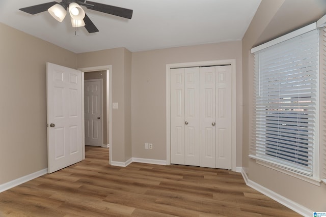 unfurnished bedroom with a closet, ceiling fan, and hardwood / wood-style flooring