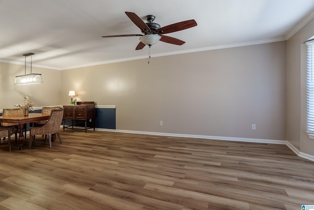 dining room with ceiling fan, a healthy amount of sunlight, wood-type flooring, and crown molding