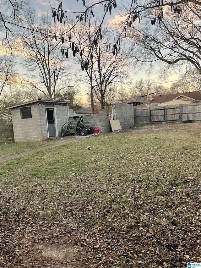 yard at dusk featuring a storage shed