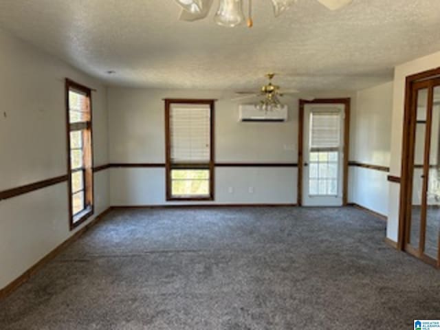 spare room with dark colored carpet, ceiling fan, and a healthy amount of sunlight