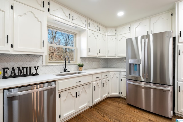 kitchen featuring white cabinets, sink, tasteful backsplash, dark hardwood / wood-style flooring, and stainless steel appliances