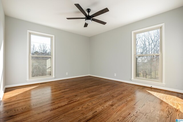 unfurnished room featuring ceiling fan, hardwood / wood-style floors, and a healthy amount of sunlight