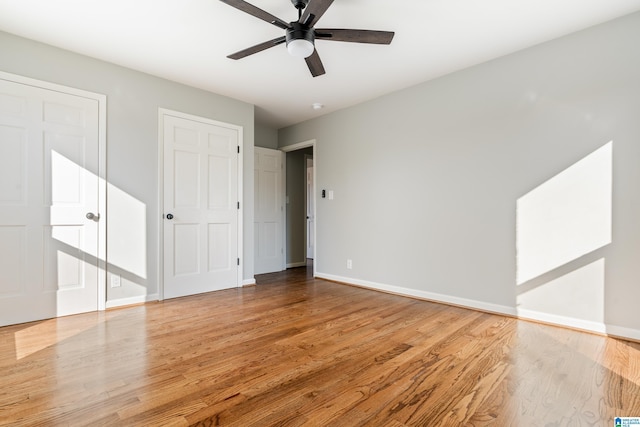 unfurnished bedroom with multiple closets, ceiling fan, and light hardwood / wood-style floors