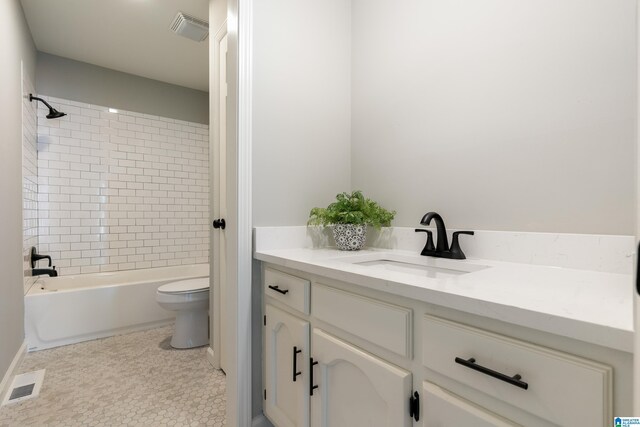 full bathroom featuring tile patterned floors, vanity, toilet, and tiled shower / bath