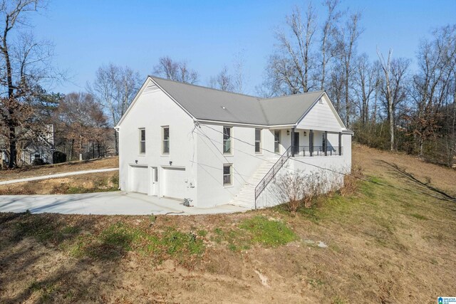 view of property exterior featuring covered porch and a garage