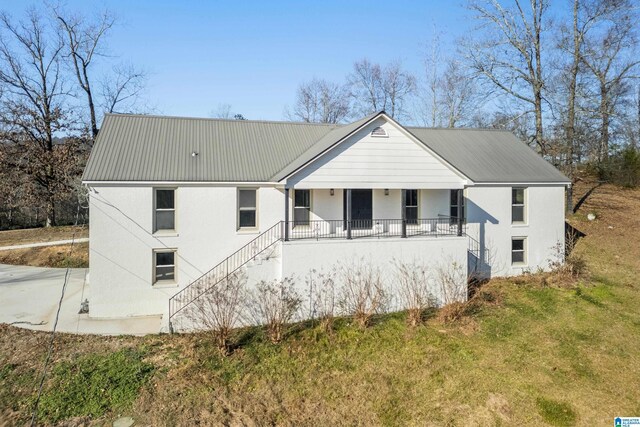 view of front of home featuring covered porch and a front lawn