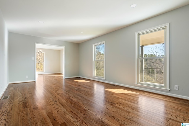 unfurnished room featuring wood-type flooring and an inviting chandelier