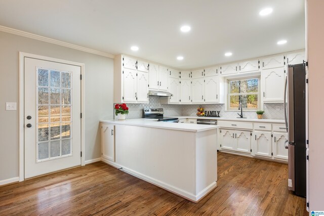 kitchen with white cabinets, sink, dark hardwood / wood-style floors, appliances with stainless steel finishes, and kitchen peninsula