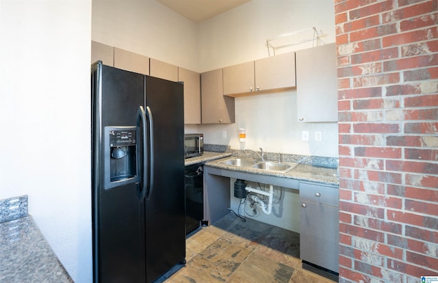 kitchen featuring sink, black fridge with ice dispenser, and stone countertops