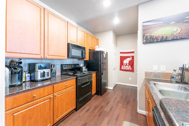 kitchen with sink, dark hardwood / wood-style floors, black appliances, a textured ceiling, and decorative backsplash