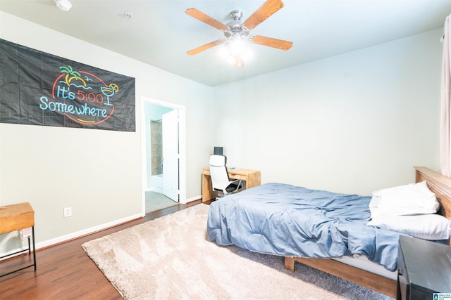 bedroom featuring dark hardwood / wood-style flooring, ceiling fan, and ensuite bathroom