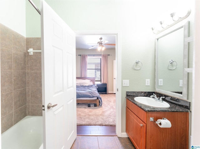 bathroom with vanity, a bath, and ceiling fan