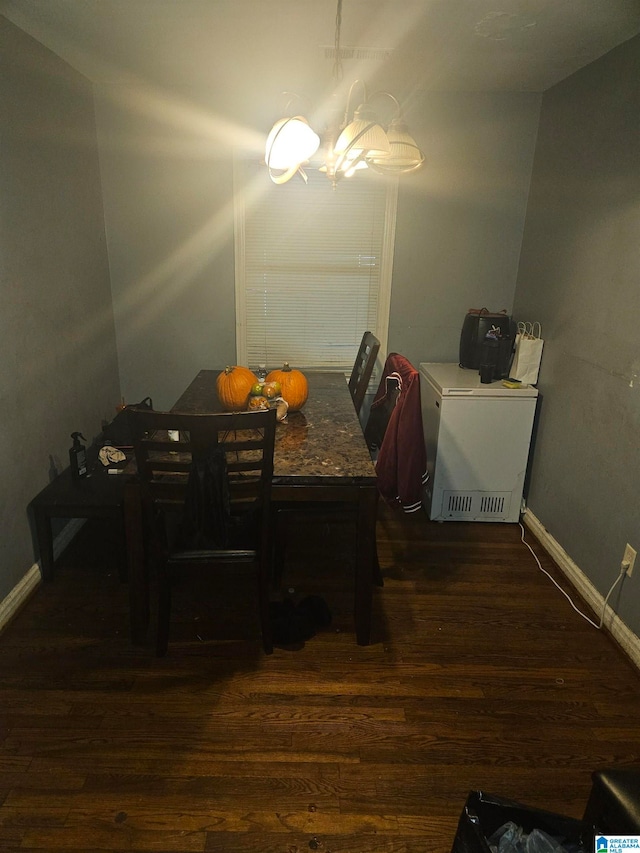 dining space with an inviting chandelier and dark wood-type flooring