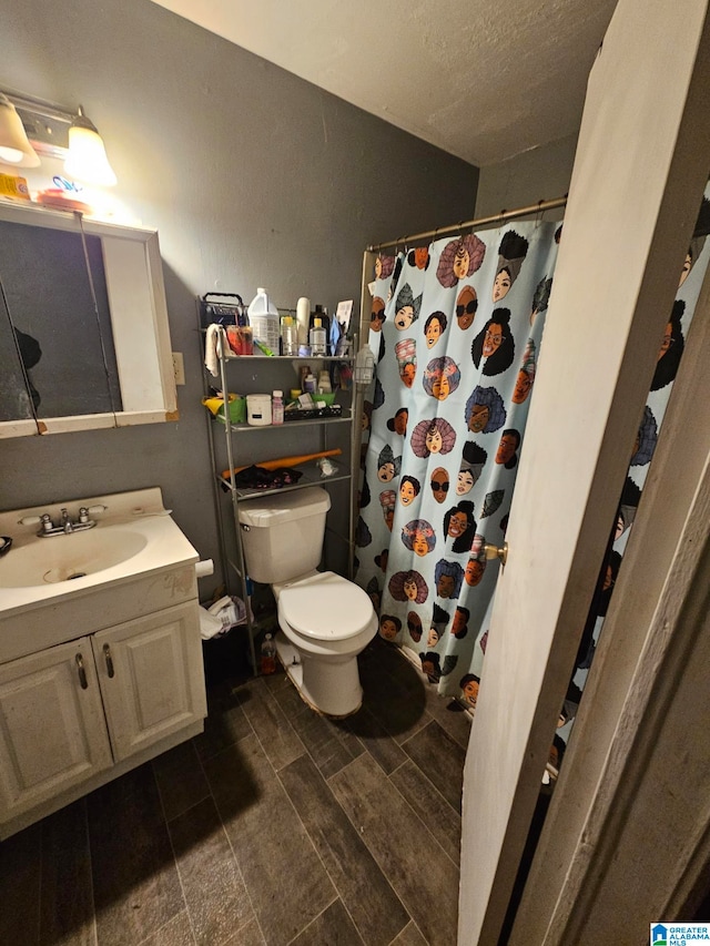 bathroom with vanity, a textured ceiling, and toilet