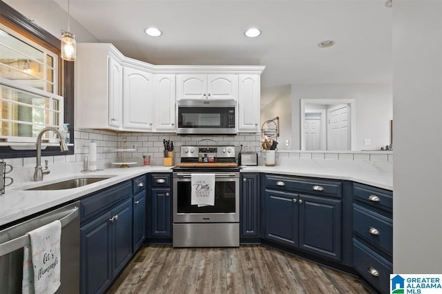 kitchen with white cabinets, blue cabinets, sink, dark hardwood / wood-style floors, and appliances with stainless steel finishes