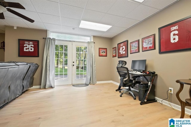 home office with a paneled ceiling, ceiling fan, french doors, and light hardwood / wood-style flooring