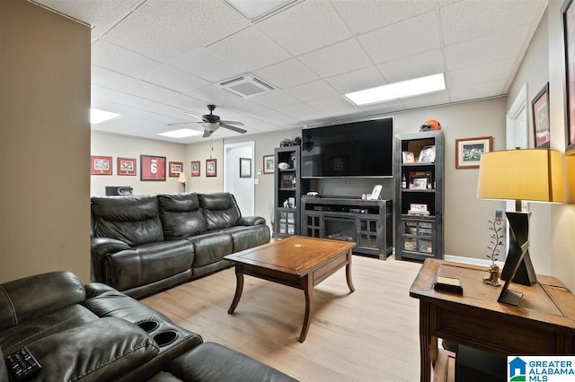 living room featuring ceiling fan, a drop ceiling, and hardwood / wood-style floors