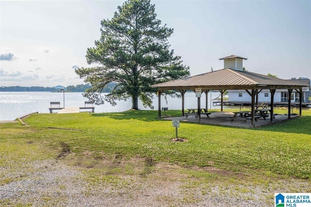 view of property's community with a gazebo, a water view, and a lawn