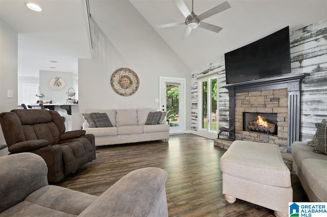 living room with ceiling fan, a fireplace, high vaulted ceiling, and dark wood-type flooring