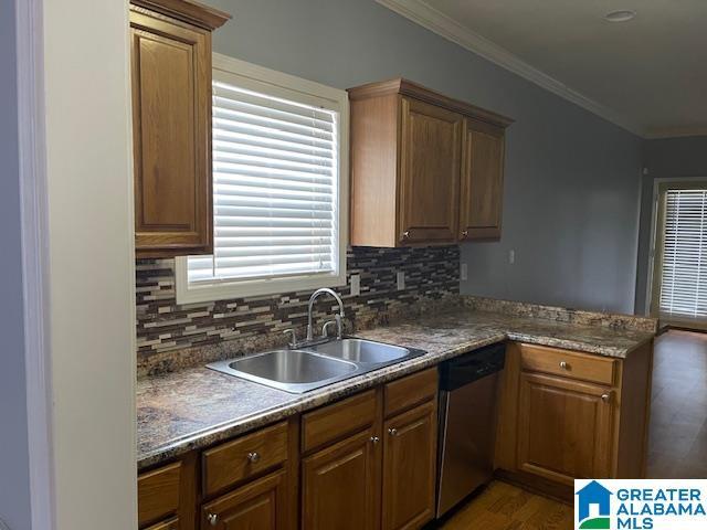 kitchen featuring dark hardwood / wood-style flooring, backsplash, stainless steel dishwasher, ornamental molding, and sink