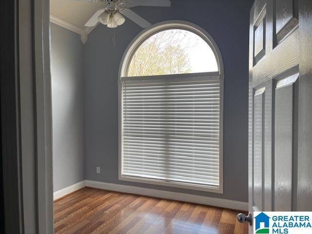 unfurnished room with dark hardwood / wood-style flooring, ceiling fan, and crown molding