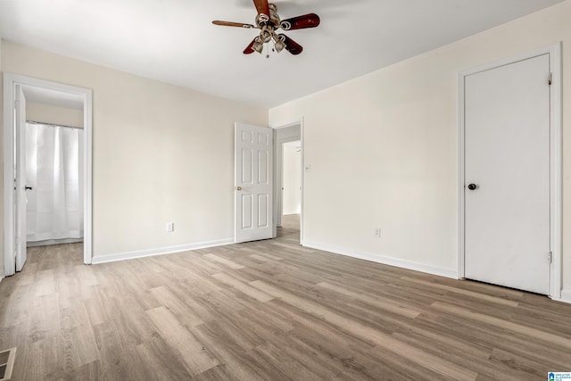 unfurnished bedroom with ceiling fan, connected bathroom, and light hardwood / wood-style flooring