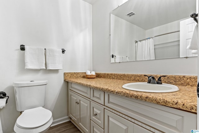 bathroom featuring curtained shower, vanity, hardwood / wood-style flooring, and toilet