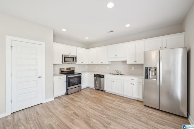 kitchen featuring light wood-type flooring, white cabinetry, sink, and appliances with stainless steel finishes