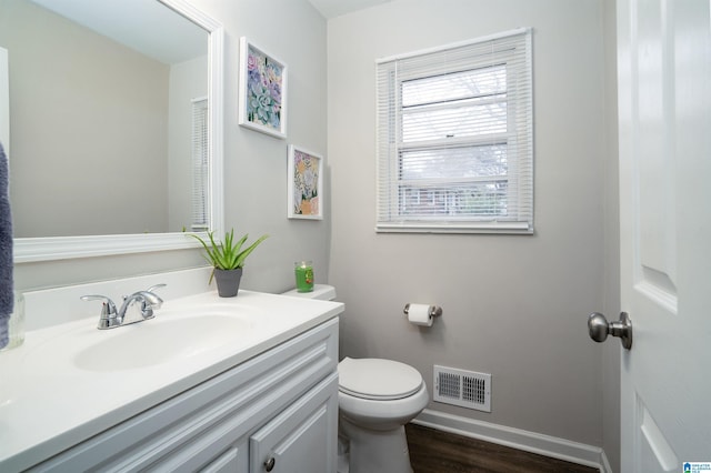 bathroom featuring vanity, wood-type flooring, and toilet