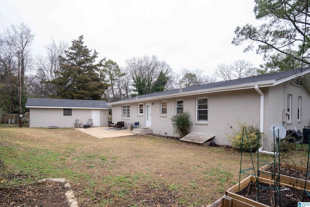 rear view of property featuring an outdoor structure, a patio area, and a lawn