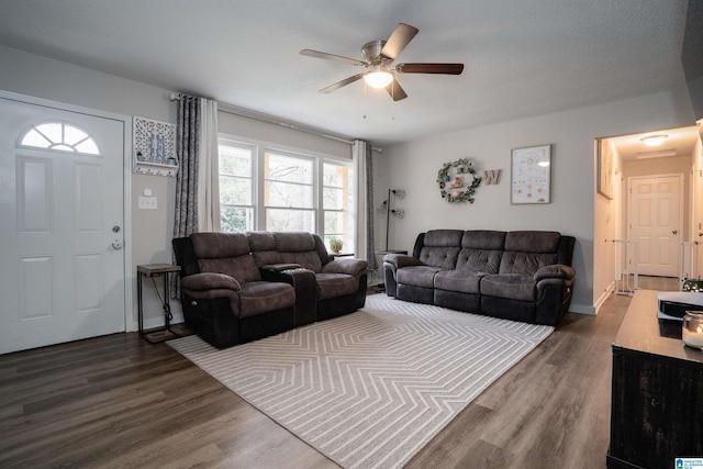 living room with ceiling fan, dark hardwood / wood-style flooring, and a textured ceiling