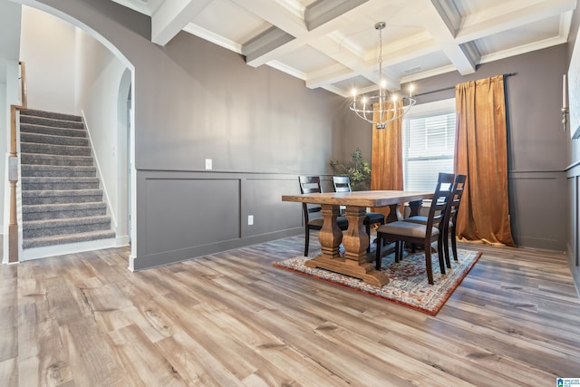 dining area featuring beamed ceiling, wood-type flooring, a chandelier, and coffered ceiling