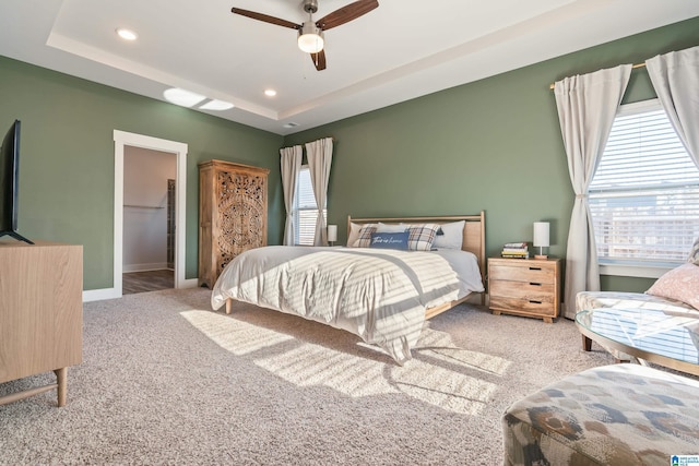 bedroom featuring carpet flooring, ceiling fan, a raised ceiling, and a spacious closet