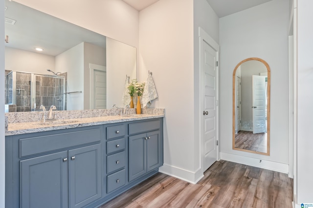 bathroom featuring vanity, an enclosed shower, and hardwood / wood-style flooring