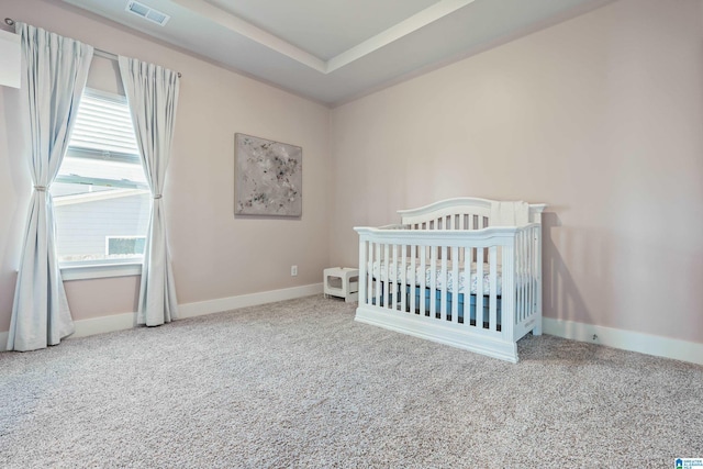 carpeted bedroom featuring a nursery area