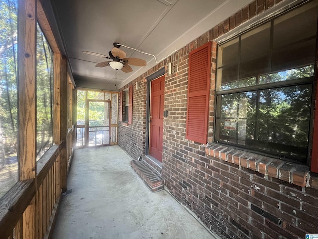 unfurnished sunroom with ceiling fan