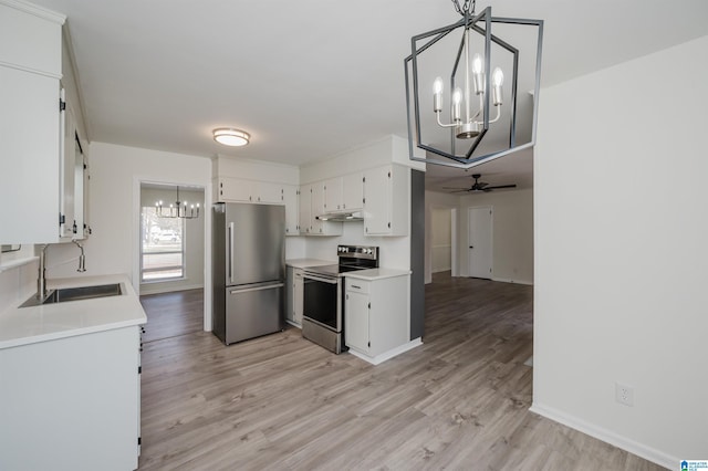 kitchen with light hardwood / wood-style floors, white cabinetry, hanging light fixtures, stainless steel appliances, and ceiling fan with notable chandelier