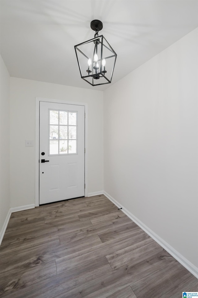 doorway to outside featuring hardwood / wood-style floors and an inviting chandelier