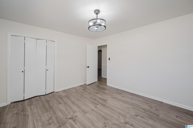 unfurnished bedroom with light hardwood / wood-style floors and a closet