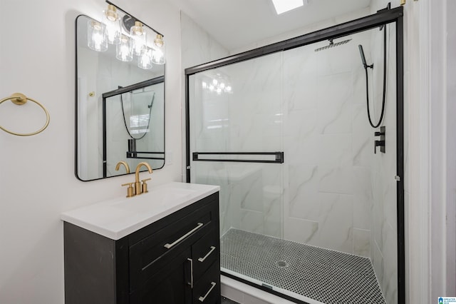 bathroom with a shower with shower door and vanity